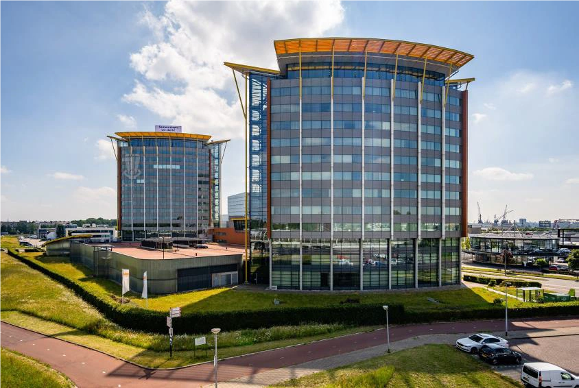 Twee moderne kantoorgebouwen aan de Karel Doormanweg met grote glasgevels en een opvallend oranje dak.